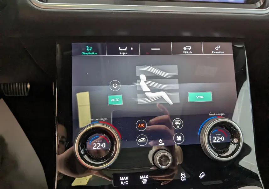 Écran tactile de la climatisation du Range Rover Velar noir, affichant 22°C avec réglages sièges et ventilation.