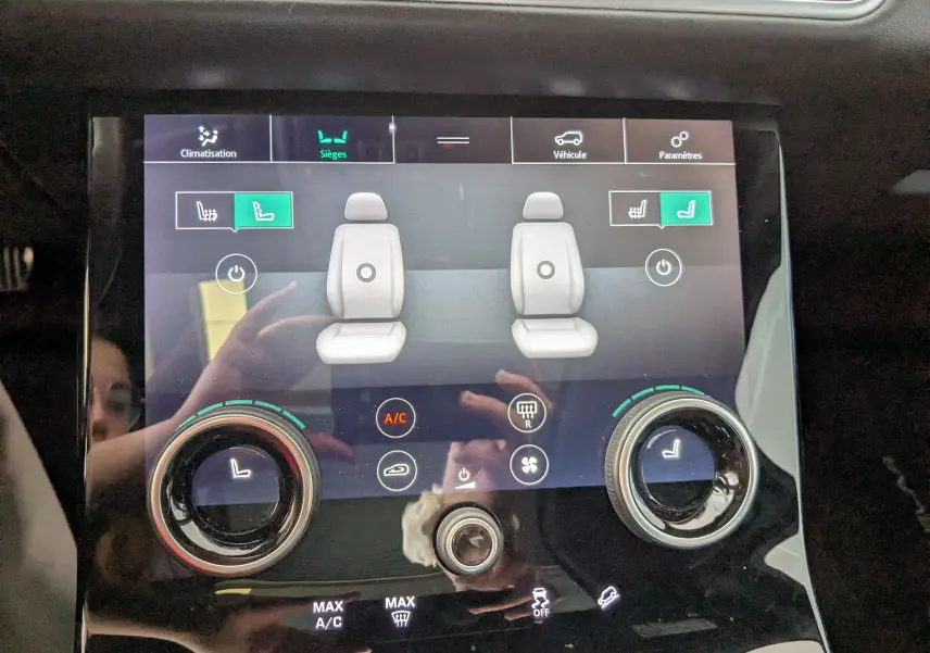 Écran tactile du système de climatisation et sièges chauffants du Range Rover Velar noir, vue rapprochée du tableau de bord.