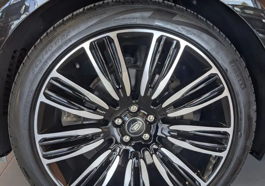 Gros plan sur la jante avant droite noire et chromée du Range Rover Velar 3.0D V6 2020 noir avec logo Land Rover central.