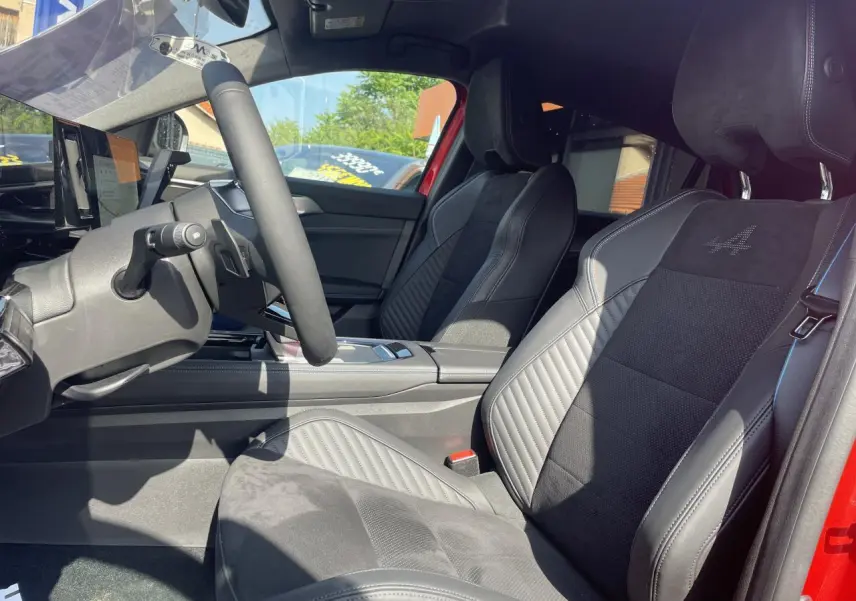 Intérieur côté conducteur de la Renault Rafale rouge, sièges sport Alcantara avec logo Alpine brodé sur appuie-tête.