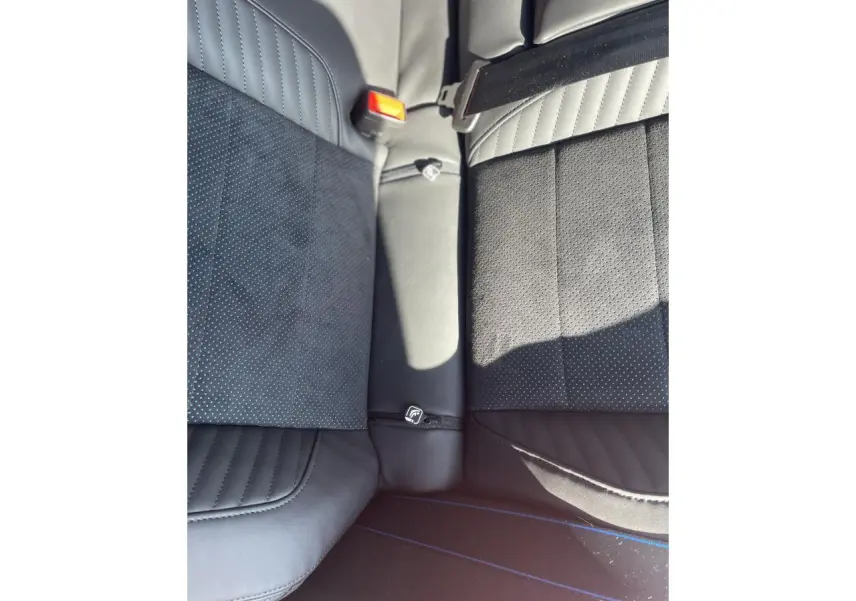 Gros plan sur la banquette arrière noire avec surpiqûres bleues et ceinture de sécurité rouge de la Renault Rafale Esprit Alpine 2025