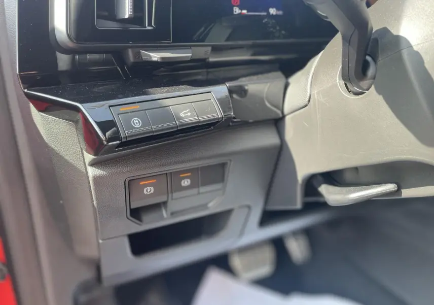 Gros plan sur les commandes sous le tableau de bord côté gauche du Renault Rafale rouge et noir, version Esprit Alpine 2025.