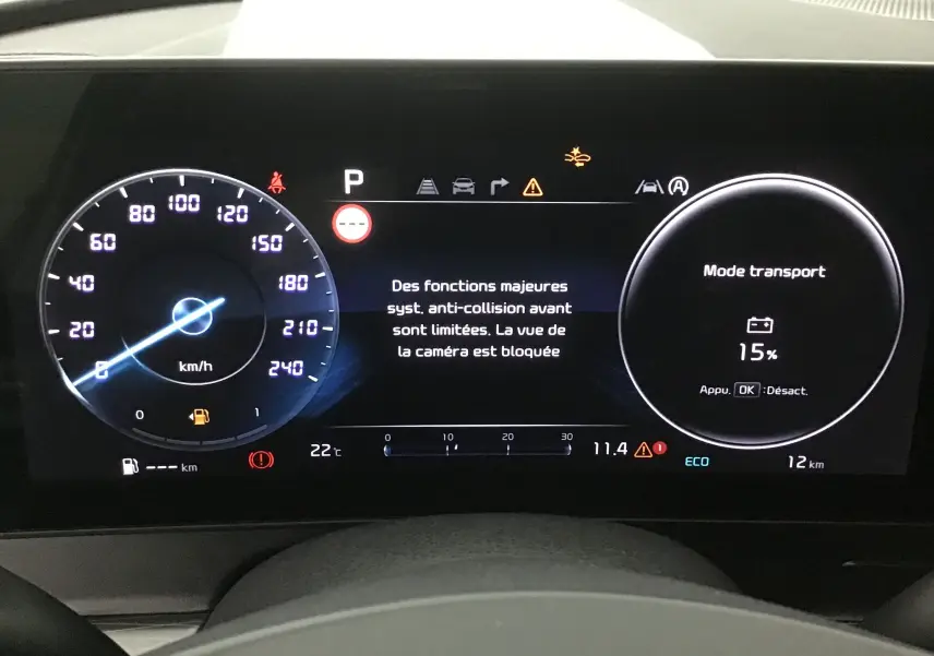 Combiné d'instrumentation digital 12,3'' du Kia Sportage blanc 2025 affichant mode transport et alertes système.