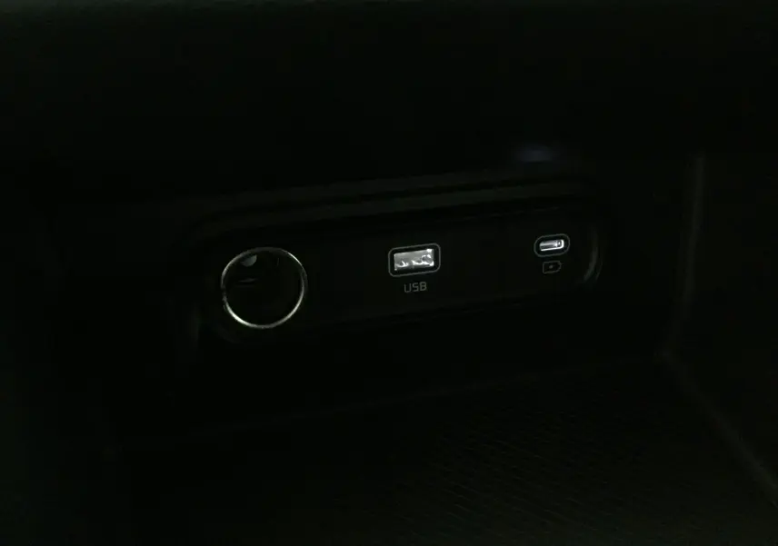 Prise USB et port USB-C intégrés dans la console centrale d'un Kia Sportage blanc 2025, version Style.