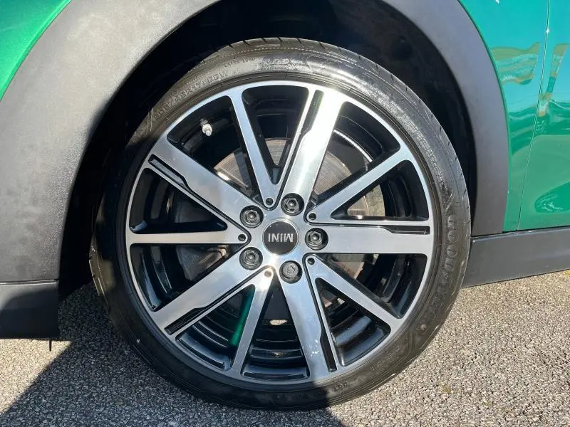 Gros plan sur la jante alliage 17 pouces design Roulette Spoke noire et argentée d'une MINI Cooper S British Racing Green côté gauche.