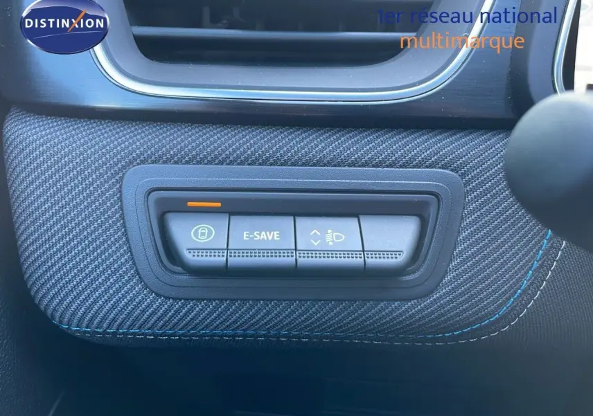 Gros plan sur les commandes E-SAVE et réglage des phares du tableau de bord du Renault Captur bleu Iron Metal toit noir.