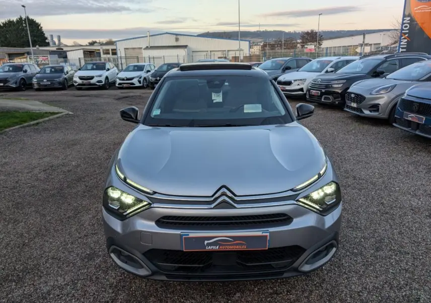 Citroën C4 gris métallisé vue de face avec phares LED allumés et toit ouvrant vitré visible.