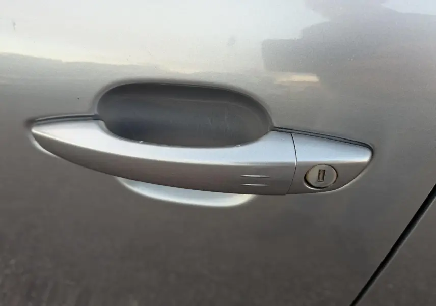 Poignée de porte côté gauche gris métallisé d'une Citroën C4 2022 avec serrure intégrée.