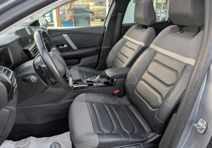 Vue intérieure côté conducteur de la Citroën C4 2022 gris, sièges Advanced Comfort cuir et textile noir, volant cuir.