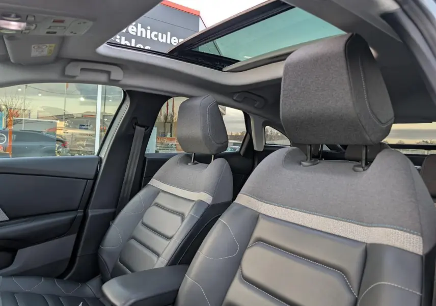 Vue intérieure avant de la Citroën C4 2022, sièges Advanced Comfort gris et toit ouvrant vitré partiellement ouvert.