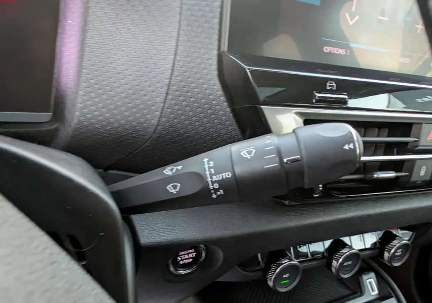 Gros plan sur la commande d’essuie-glace côté gauche du tableau de bord noir de la Citroën C4 gris métallisé.