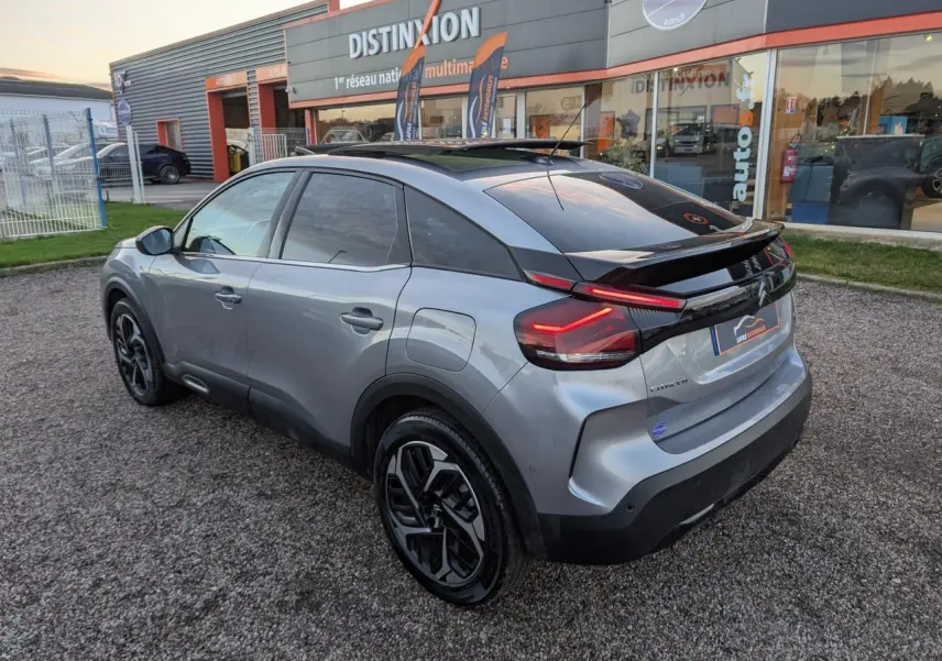 Citroën C4 gris métallisé vue 3/4 arrière droit avec toit ouvrant vitré et jantes alliage 18 pouces.