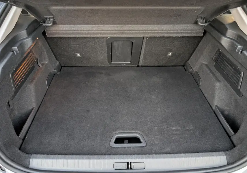 Coffre ouvert vu de l'arrière d'une Citroën C4 gris, avec plancher plat et trappe à skis intégrée.