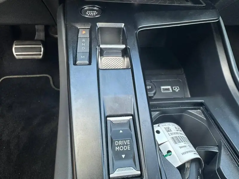 Vue rapprochée de la console centrale noire de la Peugeot 308 GT 2022 avec sélecteur de boîte auto et bouton Drive Mode.