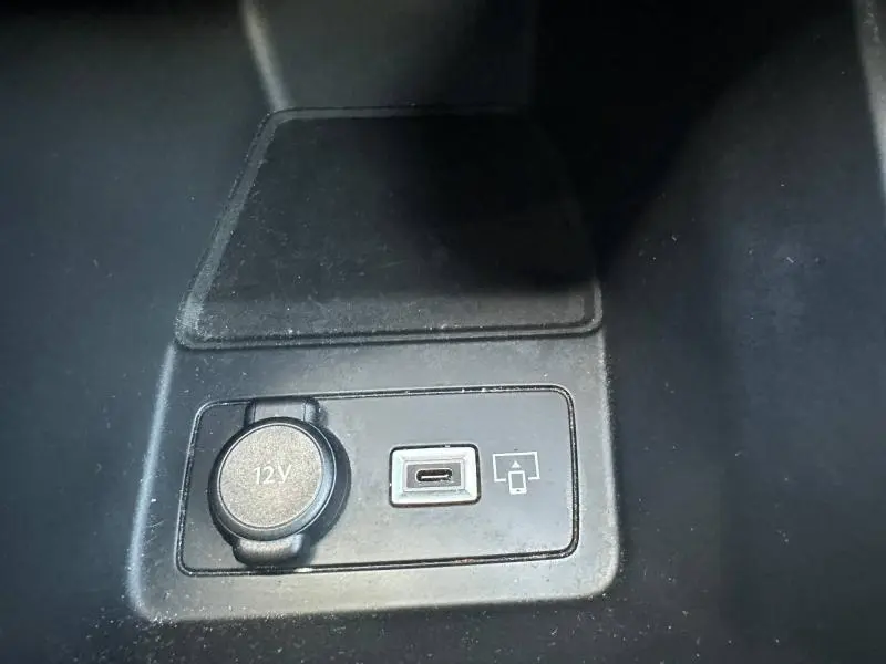 Prise 12V et port USB-C dans la console centrale d’une Peugeot 308 gris Artense, vue en plongée.