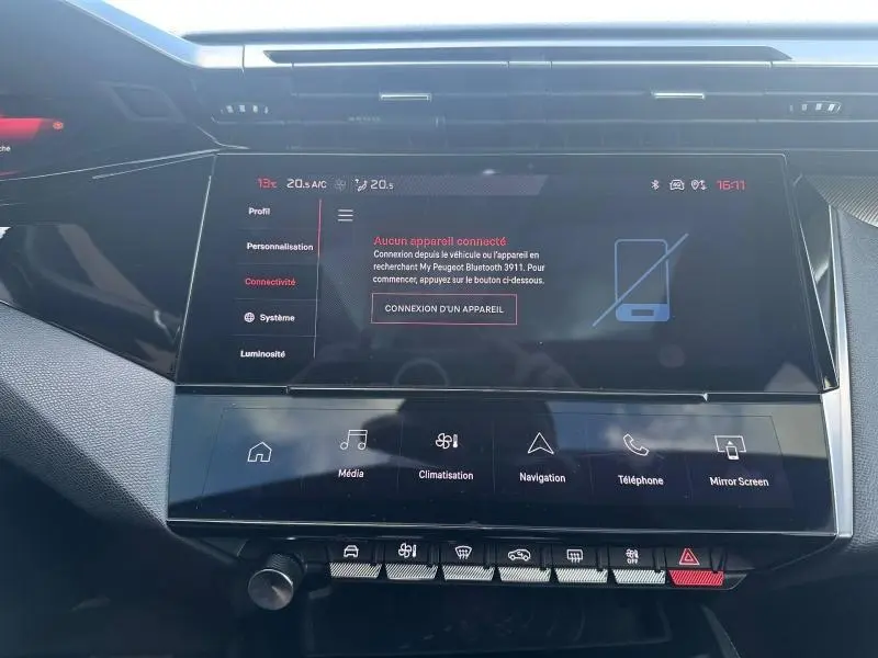 Vue rapprochée de l’écran tactile central et de la console de la Peugeot 308 gris Artense, affichant les options connectivité et climatisation.
