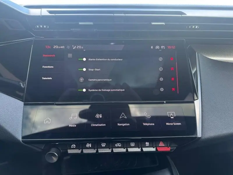 Vue rapprochée de l'écran tactile central et de la console de la Peugeot 308 gris Artense, affichant les réglages du véhicule.