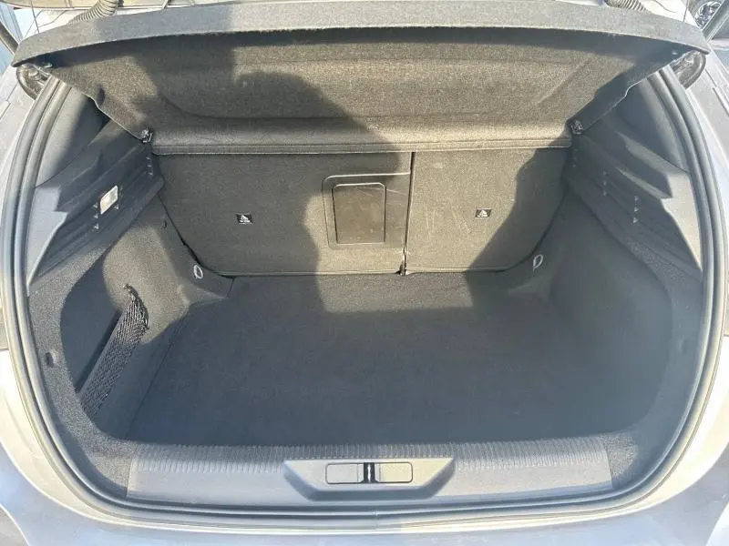 Coffre ouvert de la Peugeot 308 gris Artense, vue de l'arrière montrant l'espace de chargement et la trappe à skis centrale.