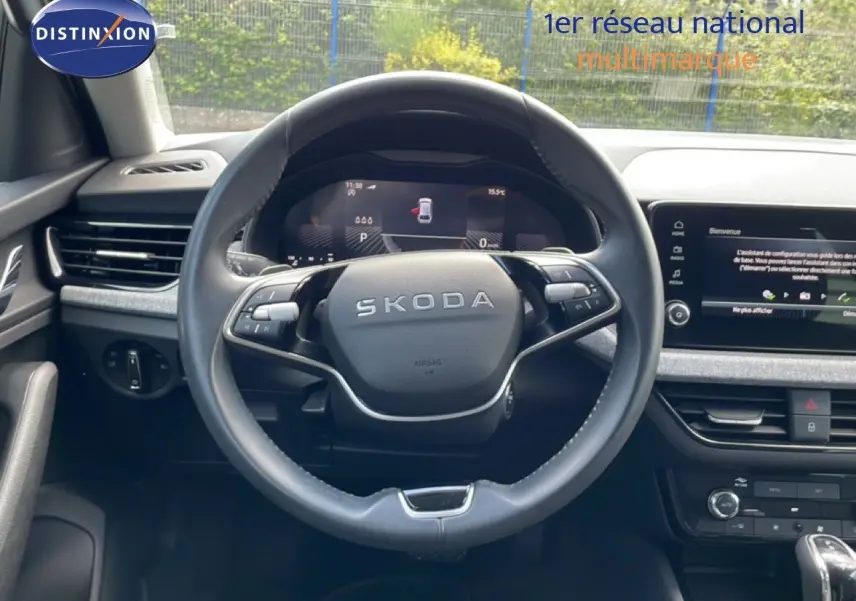 Vue intérieure centrée sur le volant noir de la Skoda Scala 2025 avec tableau de bord digital et écran tactile.
