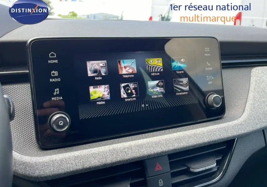 Écran tactile central de la Skoda Scala blanc glacier 2025, vue rapprochée du tableau de bord avec interface multimédia.