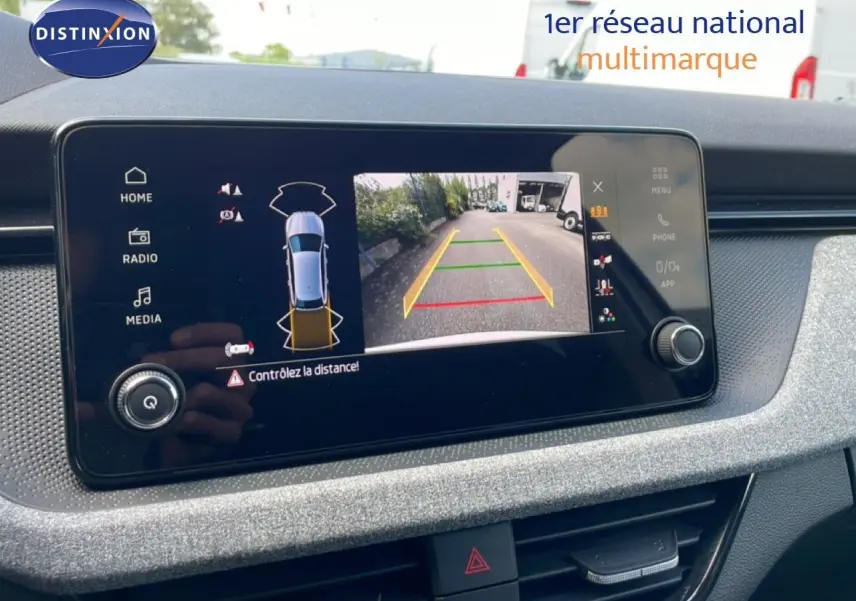 Écran tactile intérieur montrant la caméra de recul active d'une Skoda Scala blanc glacier, vue de face.