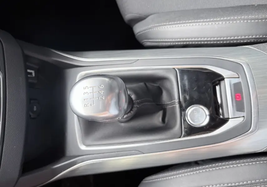 Gros plan sur le levier de vitesses manuel et bouton démarrage de la Peugeot 308 BlueHDi gris foncé, intérieur cuir noir.