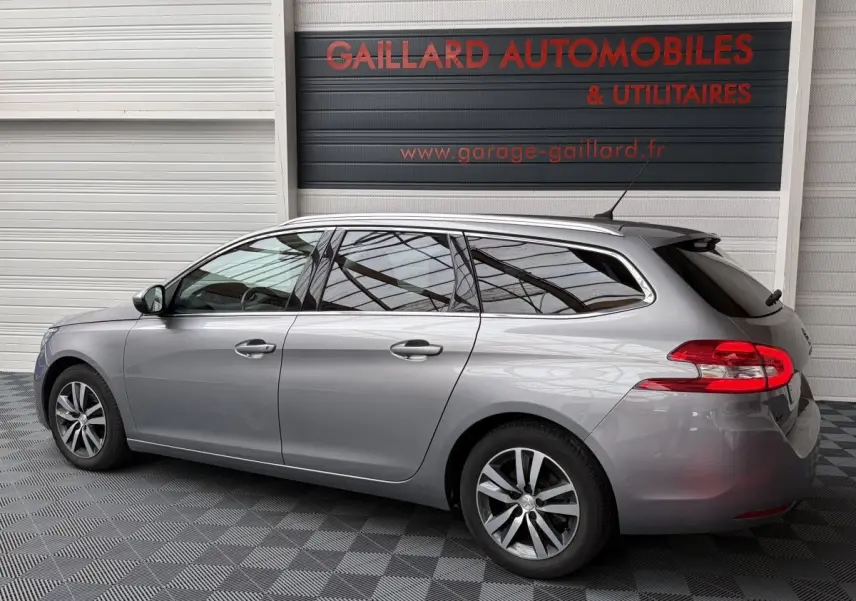 Peugeot 308 BlueHDi 130 gris foncé en profil droit, break avec vitres teintées et jantes alliage.