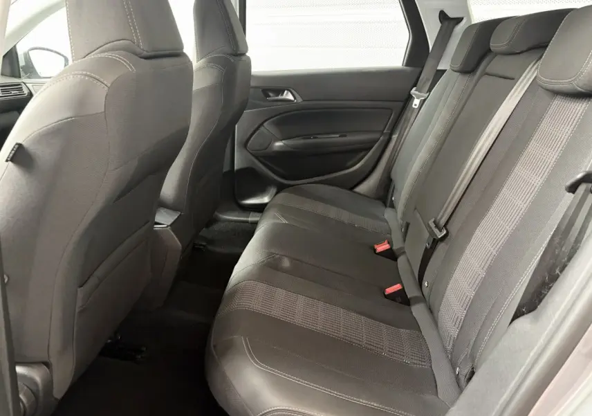 Vue latérale intérieure montrant la banquette arrière noire et les dossiers des sièges avant d'une Peugeot 308 gris foncé.