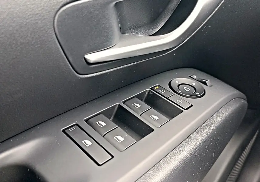 Gros plan sur les commandes de lève-vitres et rétroviseurs côté conducteur du Hyundai Tucson gris Ecotronique 2026.