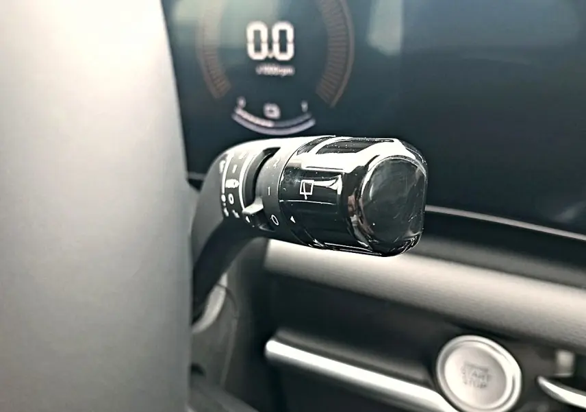 Gros plan sur la manette de commande noire à gauche du volant dans l’habitacle du Hyundai Tucson gris écotronique.