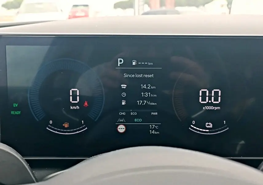 Tableau de bord numérique du Hyundai Tucson gris, affichant vitesse, régime moteur et informations hybrides.