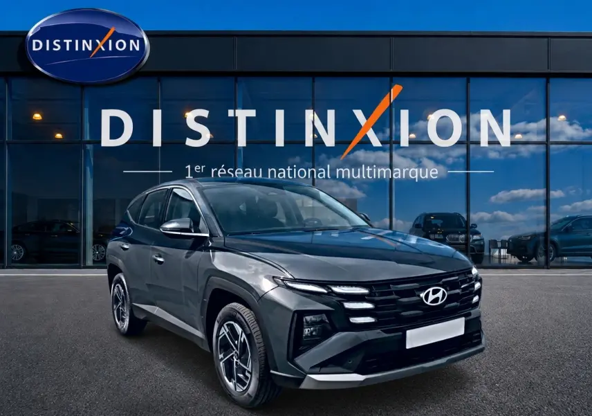 Hyundai Tucson 2026 gris ecotronique en 3/4 avant droit devant vitrine Distinxion, jantes alliage 17 pouces.