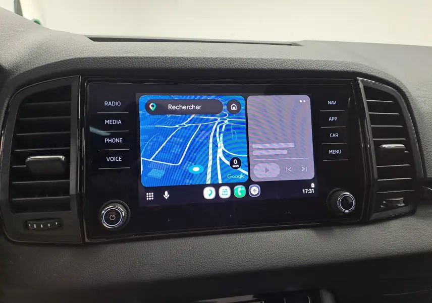 Écran central tactile du tableau de bord du Skoda Karoq blanc lune, affichant la navigation GPS et commandes multimédia.