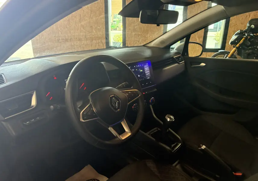Vue intérieure côté conducteur de la Renault Clio 1.5 BlueDCI Business 2022 avec volant multifonction et écran tactile central.