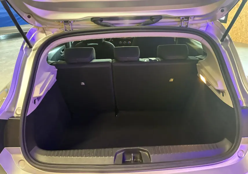 Coffre ouvert d'une Renault Clio 1.5 BlueDCI Business gris, vue arrière montrant l'espace de chargement et les sièges noirs.