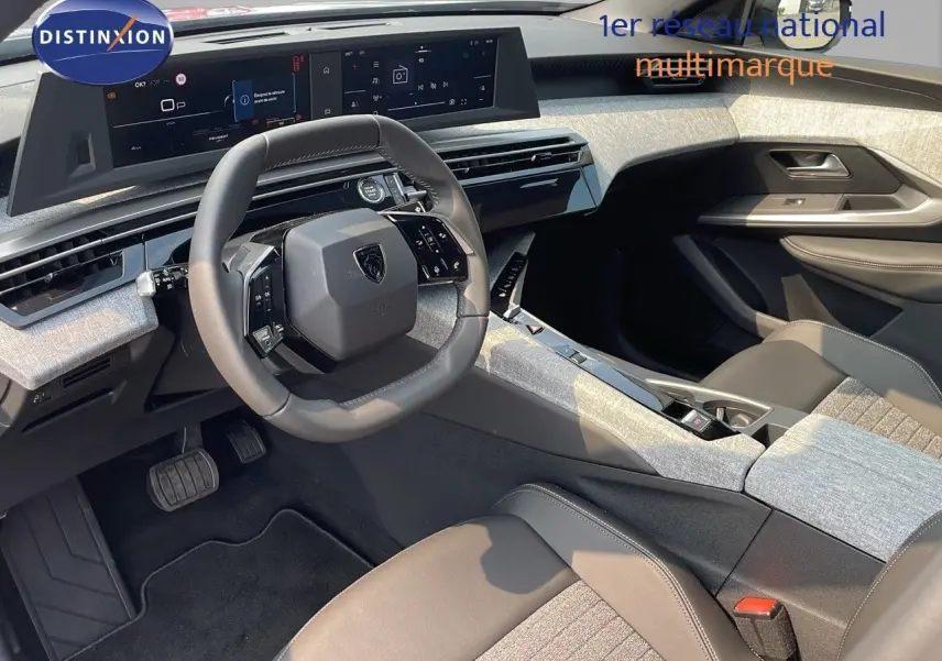 Intérieur du Peugeot 3008 Hybrid 2025 vu côté conducteur, tableau de bord moderne avec écran large et sellerie gris clair.