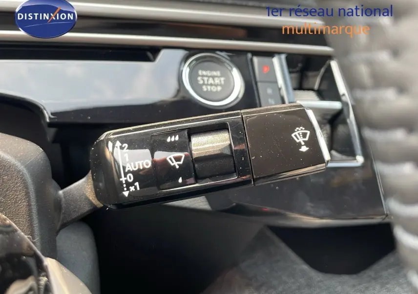 Gros plan sur la commande d’essuie-glace et bouton start du tableau de bord intérieur du Peugeot 3008 gris Artense 2025 hybride