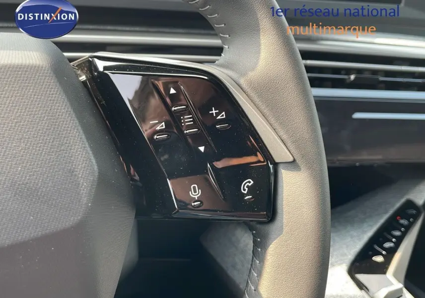 Gros plan sur les commandes au volant du Peugeot 3008 Hybrid gris Artense, mettant en valeur les boutons multifonctions.