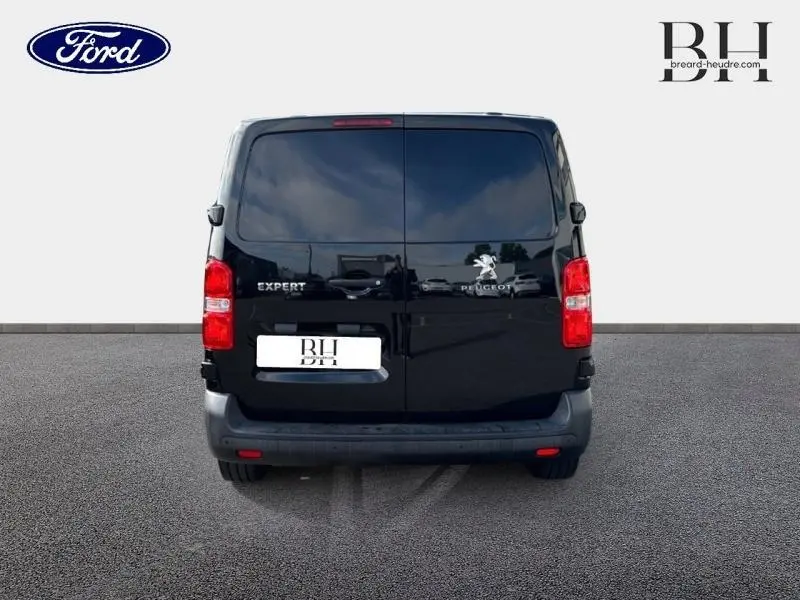 Vue arrière d'un Peugeot Expert Fourgon noir Perla Nera avec portes battantes et logo visible sur fond clair.