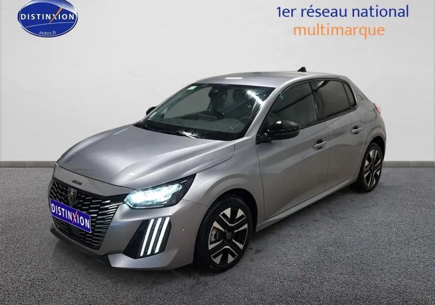 Peugeot 208 gris artense vue 3/4 avant droit avec phares LED allumés et jantes alu distinctives.