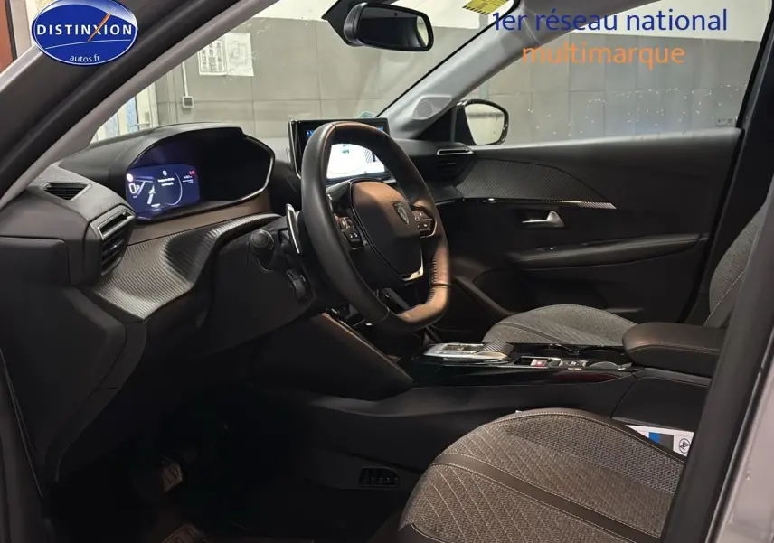 Vue intérieure côté conducteur de la Peugeot 208 1.2 hybrid 110 allure e-dcs6 avec tableau de bord numérique et sièges gris.
