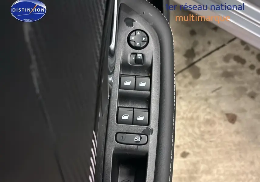 Détail des commandes des vitres électriques côté gauche intérieur d’une Peugeot 208 gris Artense.