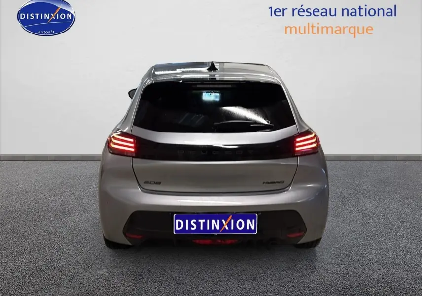 Vue arrière d'une Peugeot 208 1.2 hybrid 110 allure gris artense avec feux arrière LED allumés.