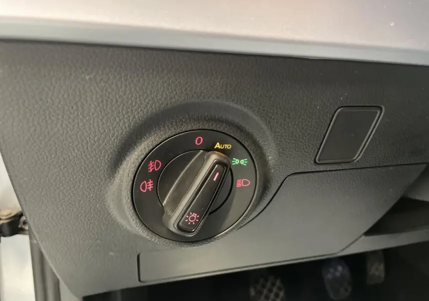 Gros plan sur le bouton de commande des phares du tableau de bord du SEAT Arona 2024, finition FR.