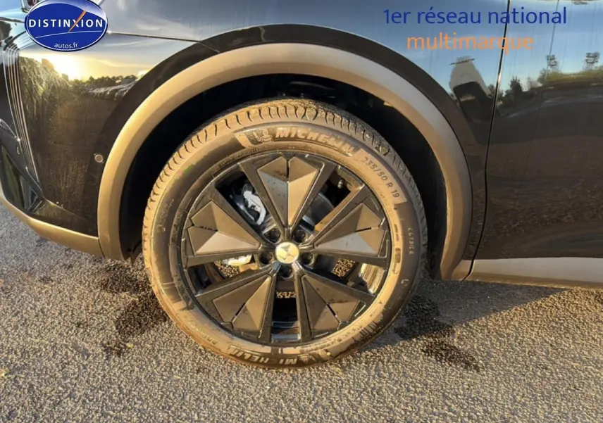 Gros plan sur la roue avant droite noire du DS7 1.5 BlueHDi 130 Performance Line avec jante alu design géométrique.