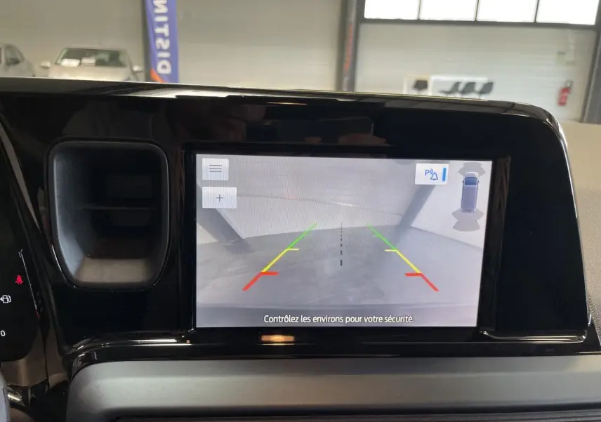 Écran tactile intérieur montrant la caméra de recul du Ford Tourneo Courier gris clair, vue frontale du tableau de bord.