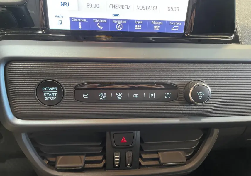 Tableau de bord du Ford Tourneo Courier 2024 avec écran tactile, bouton start/stop et commandes climatisation intégrées.