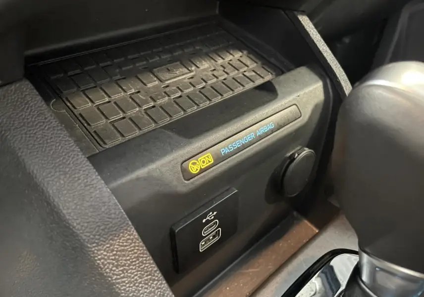 Gros plan intérieur sur la console centrale du Ford Tourneo Courier 2024 montrant port USB-C et témoin airbag passager activé.