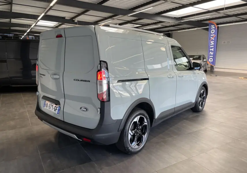 Vue 3/4 arrière droite du Ford Tourneo Courier gris clair avec jantes aluminium noires et pare-chocs noir.