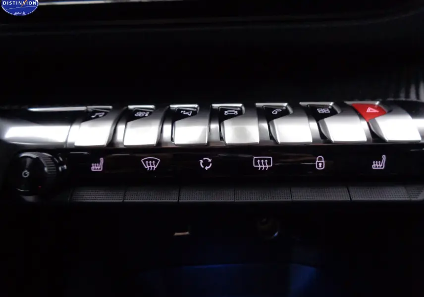 Gros plan sur la rangée de boutons argentés du tableau de bord du Peugeot 3008 noir perle 2023, avec commandes clim et alertes.